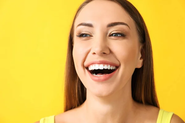 Schöne glückliche junge Frau auf farbigem Hintergrund — Stockfoto