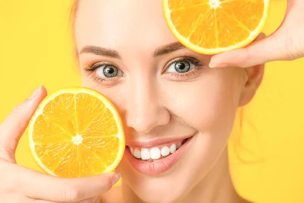 Beautiful young woman with orange slices on color background, closeup — Stock Photo, Image