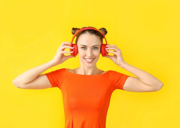 Beautiful young woman listening to music on color background — Stock Photo, Image