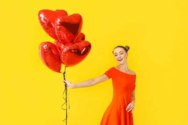 Mulher bonita com balões em forma de coração no fundo de cor — Fotografia de Stock