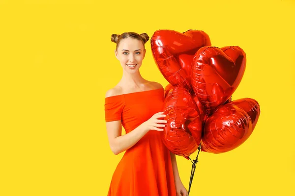 漂亮的年轻女子，有心形气球，背景是彩色的 — 图库照片