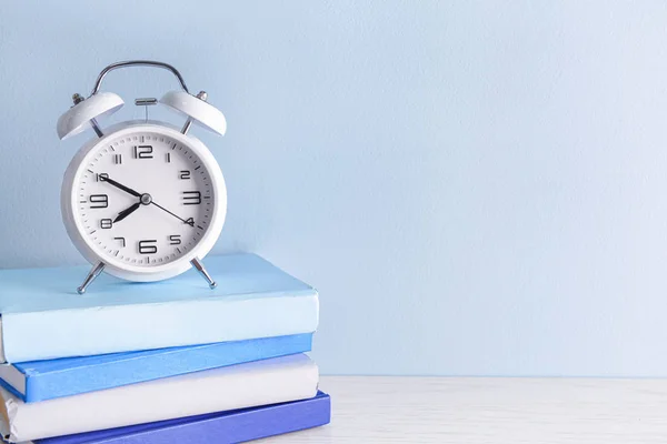 Alarm clock and books on table — Stock Photo, Image