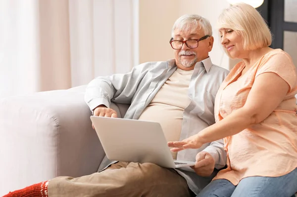 Volwassen paar met laptop rusten thuis — Stockfoto