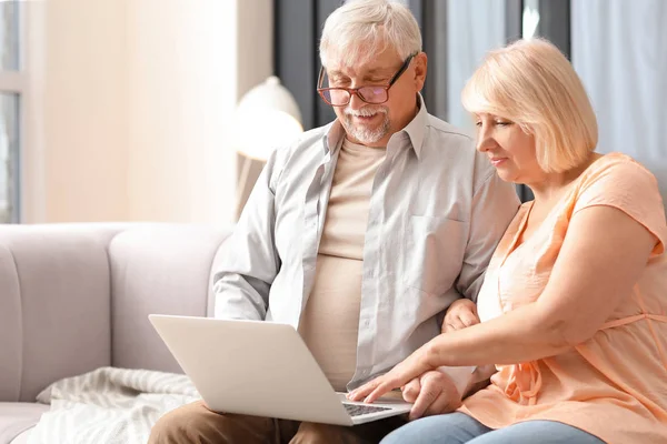 Volwassen paar met laptop rusten thuis — Stockfoto