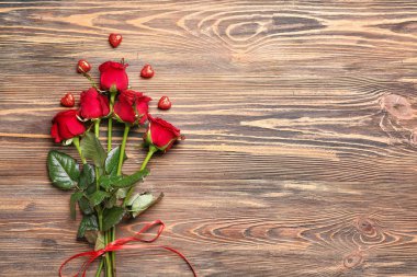 Ahşap arka planda güzel güller ve kalpler. Sevgililer Günü kutlaması