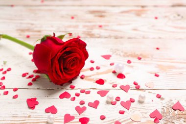 Güzel bir gül ve ahşap arka planda kalpler. Sevgililer Günü kutlaması
