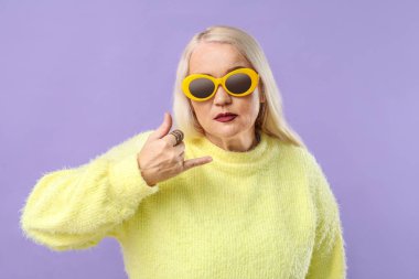 Renkli arka planda havalı, olgun bir kadın.