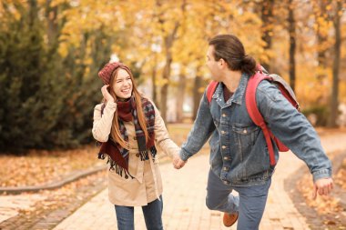 mutlu çift sonbahar Park'ta yürüyordunuz