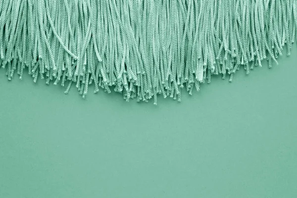 Turquoise tassels on color background — Stock Photo, Image