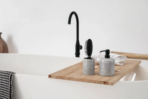 Bathtub with supplies in stylish interior — Stock Photo, Image