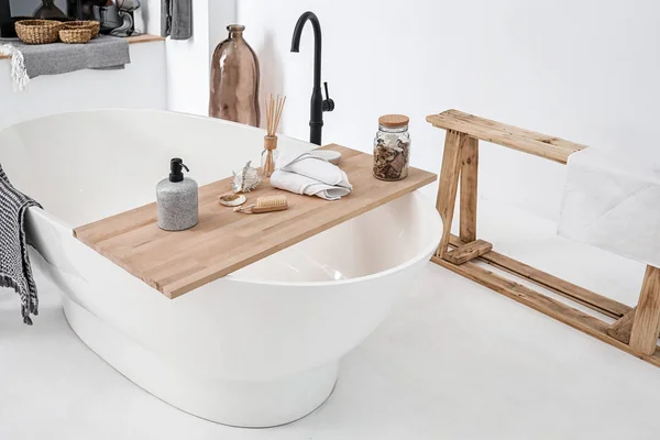 Bathtub with supplies in stylish interior — Stock Photo, Image