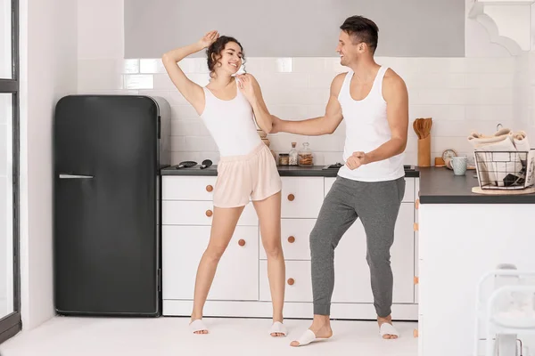 Feliz pareja joven bailando en la cocina en casa —  Fotos de Stock