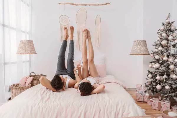 Feliz joven pareja acostada en la cama en casa —  Fotos de Stock