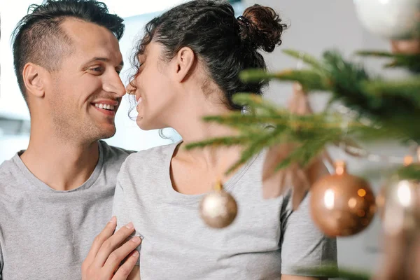 Happy young couple near Christmas tree at home — Stock Photo, Image