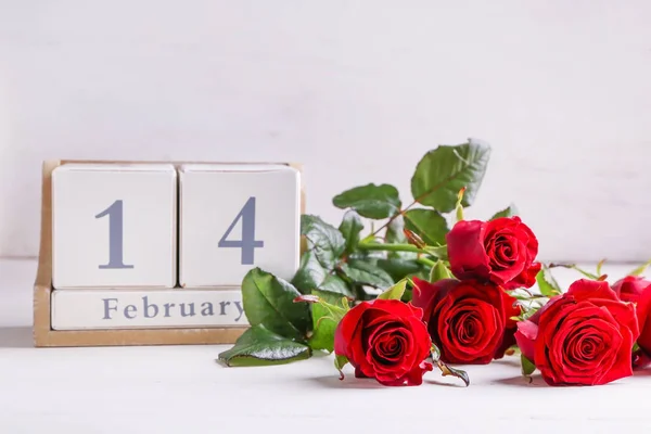 Kalendář a růže květiny na stole. Valentýnská oslava — Stock fotografie