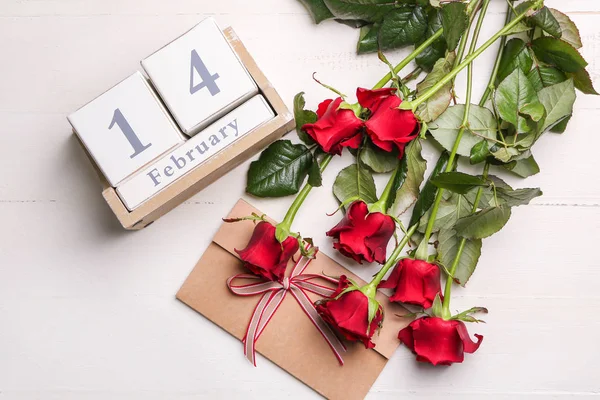 Calendário, envelope e rosa flores na mesa. Celebração do Dia dos Namorados — Fotografia de Stock