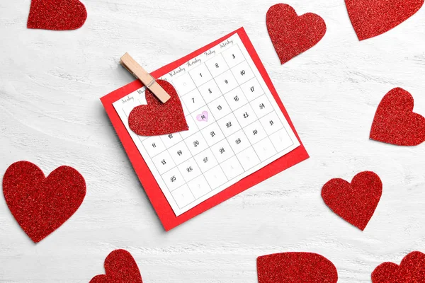 Calendário com data marcada do Dia dos Namorados e corações vermelhos no fundo de madeira branca — Fotografia de Stock