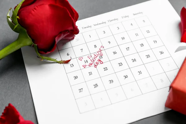 Calendário com data marcada do Dia dos Namorados e rosa no fundo cinza — Fotografia de Stock