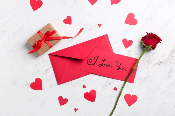 Envelopes, gift for Valentine's Day and rose on light background — Stock Photo, Image