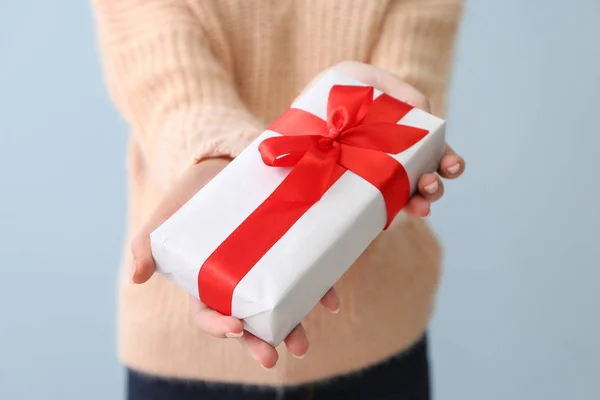 Vrouw met cadeau voor Valentijnsdag op kleur achtergrond, close-up — Stockfoto