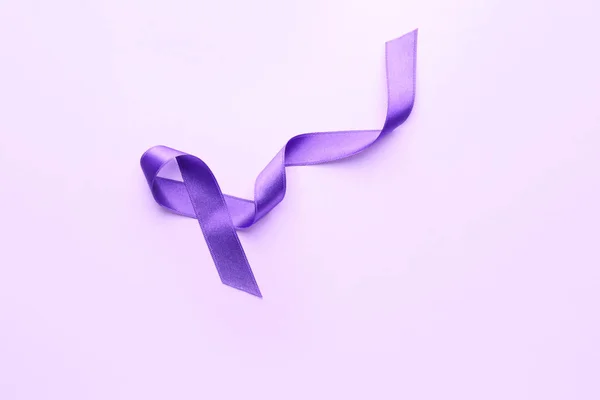 Purple ribbon as symbol of World Cancer Day on color background — Stock Photo, Image