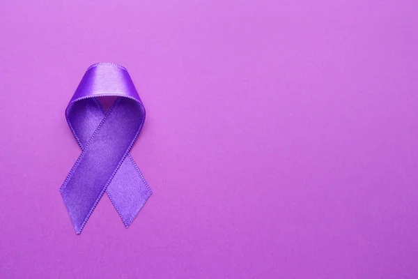 Purple ribbon as symbol of World Cancer Day on color background — Stock Photo, Image