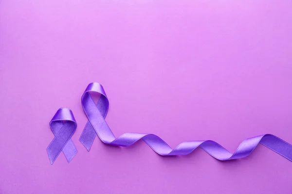 Fitas roxas como símbolo do Dia Mundial do Câncer no fundo de cor — Fotografia de Stock