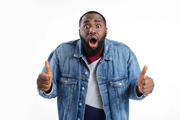 Shocked African-American man showing thumb-up on white background — Stock Photo, Image