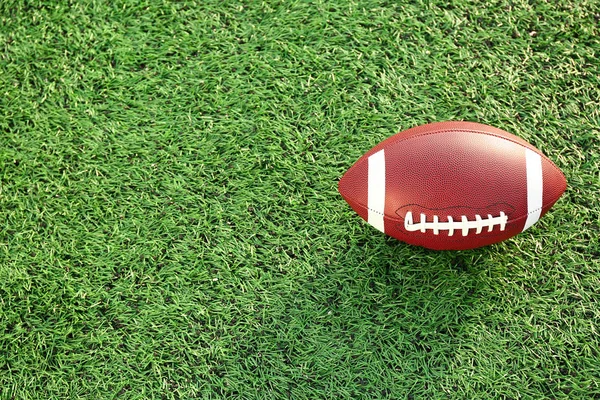 Rugby ball on green field outdoors — Stock Photo, Image