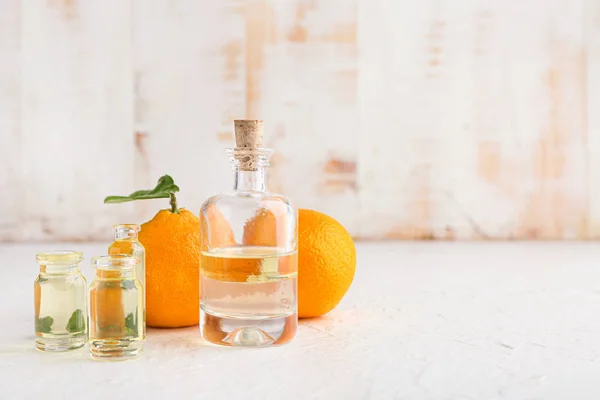 Botellas de aceite esencial de mandarina sobre la mesa — Foto de Stock