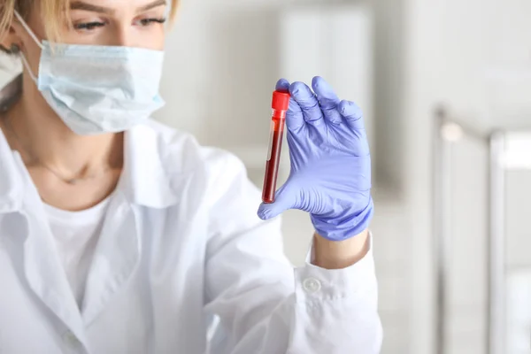 Laboratory assistant holding test tube with blood sample in clinic — Stock Photo, Image