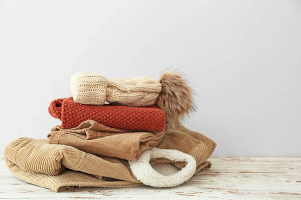 Set of warm winter clothes on table against white background — Stock Photo, Image