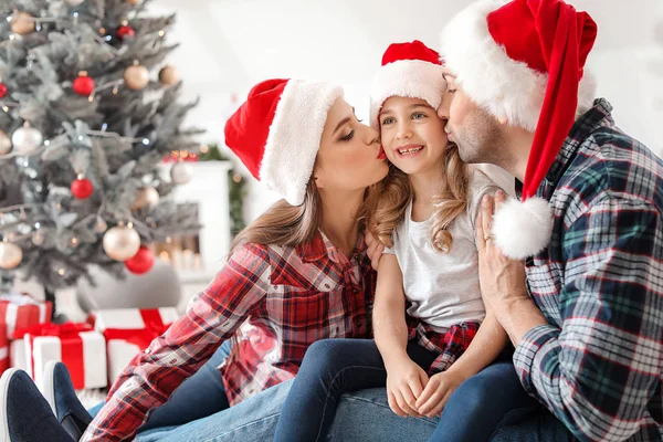 Pais beijando sua filhinha em casa na véspera de Natal — Fotografia de Stock