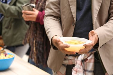 Evsiz insanlar dışarıda gönüllülerden yiyecek alıyorlar.