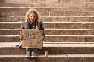 Portrait of poor homeless man sitting on stairs outdoors clipart
