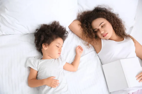 Little African-American girl with mother sleeping in bed — Stock Photo, Image