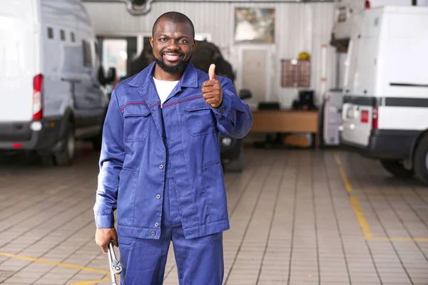 African-American mechanic showing thumb-up gesture in car service center — Stock Photo, Image