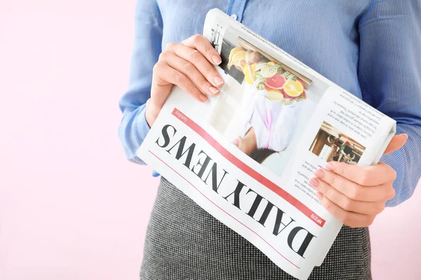 Young businesswoman with newspaper on color background, closeup — Stock Photo, Image