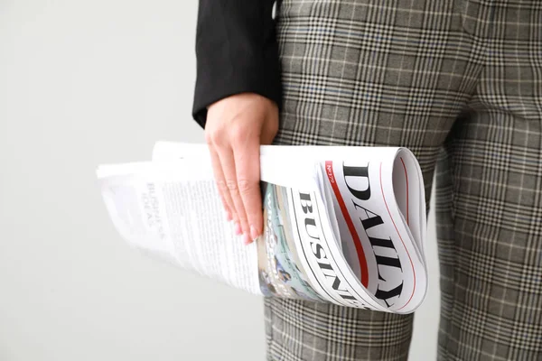 Young businesswoman with newspaper on light background, closeup — Stock Photo, Image