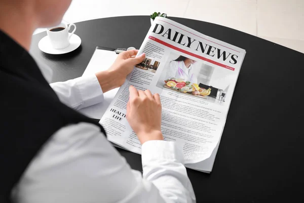 Young businesswoman reading newspaper in office — Stock Photo, Image