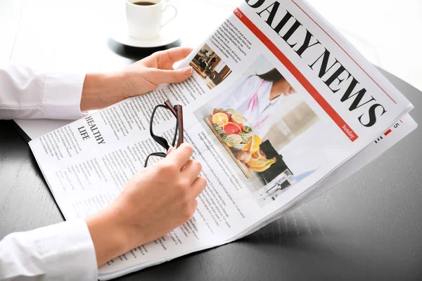 Jovem empresária lendo jornal no escritório — Fotografia de Stock