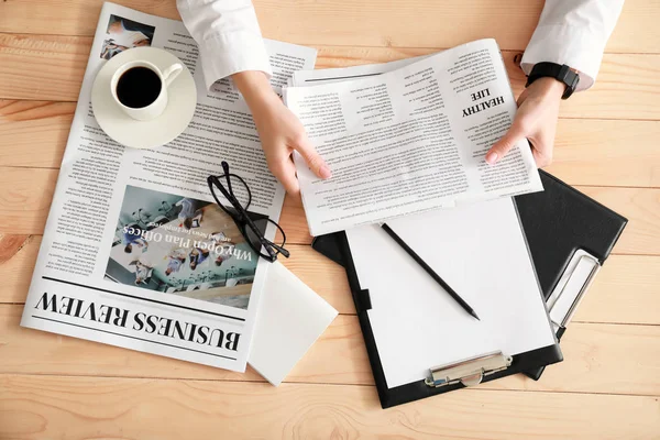 Jovem empresária lendo jornal à mesa — Fotografia de Stock