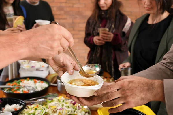 Volunteers giving food to homeless people