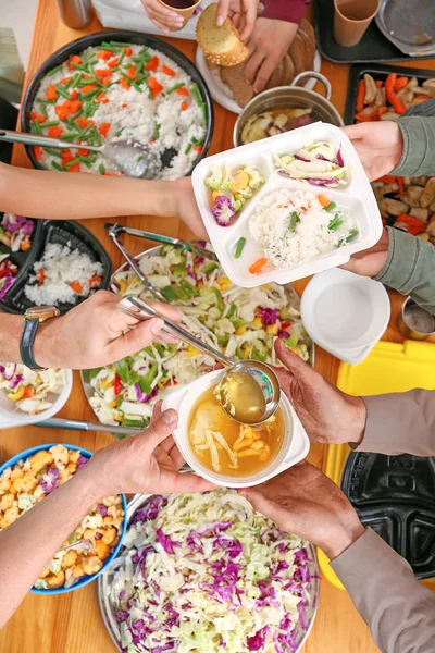 Volunteers giving food to homeless people, top view