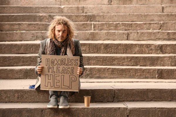 Portrait of poor homeless man sitting on stairs outdoors — Stock Photo, Image