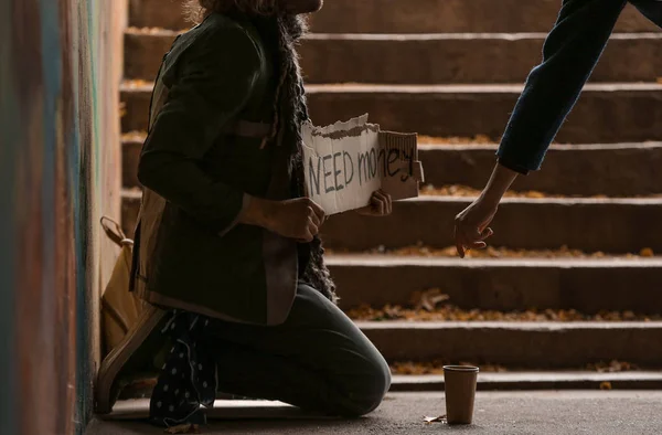 Woman giving money to poor homeless man outdoors — Stock Photo, Image