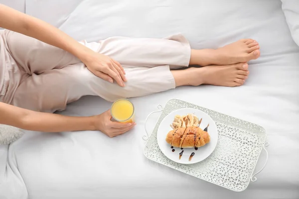Morgon med vacker ung kvinna som äter frukost på sängen — Stockfoto