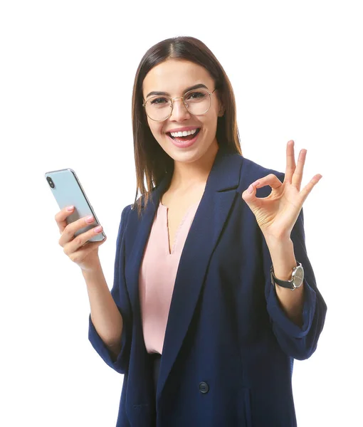 Hermosa joven empresaria con teléfono móvil que muestra OK sobre fondo blanco — Foto de Stock