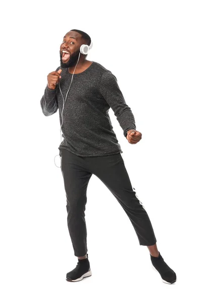Uomo afroamericano che ascolta musica su sfondo bianco — Foto Stock