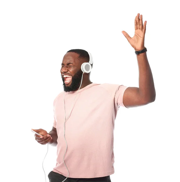 Emotional African-American man listening to music on white background — Stock Photo, Image